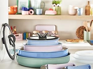 Série de contenants de rangement empilés aux couleurs pastel exposés sur le comptoir de la cuisine, montrant un système de stockage des aliments organisé avec des couvercles assortis.